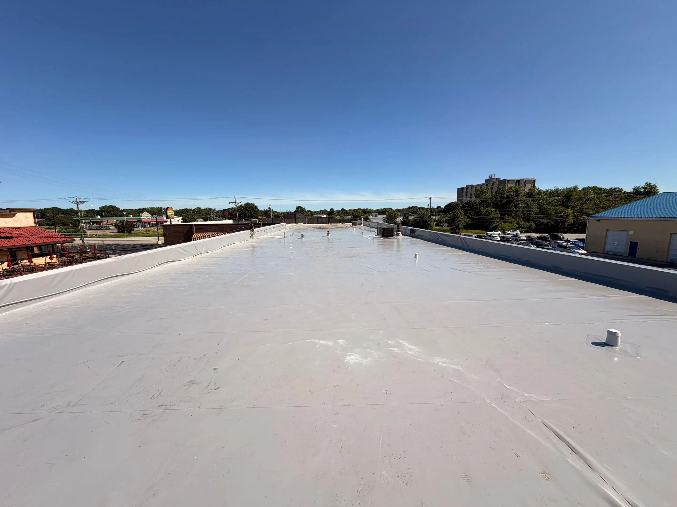 Crew finishing a white Duro-Last roof on a downtown brick building in Moline, Illinois