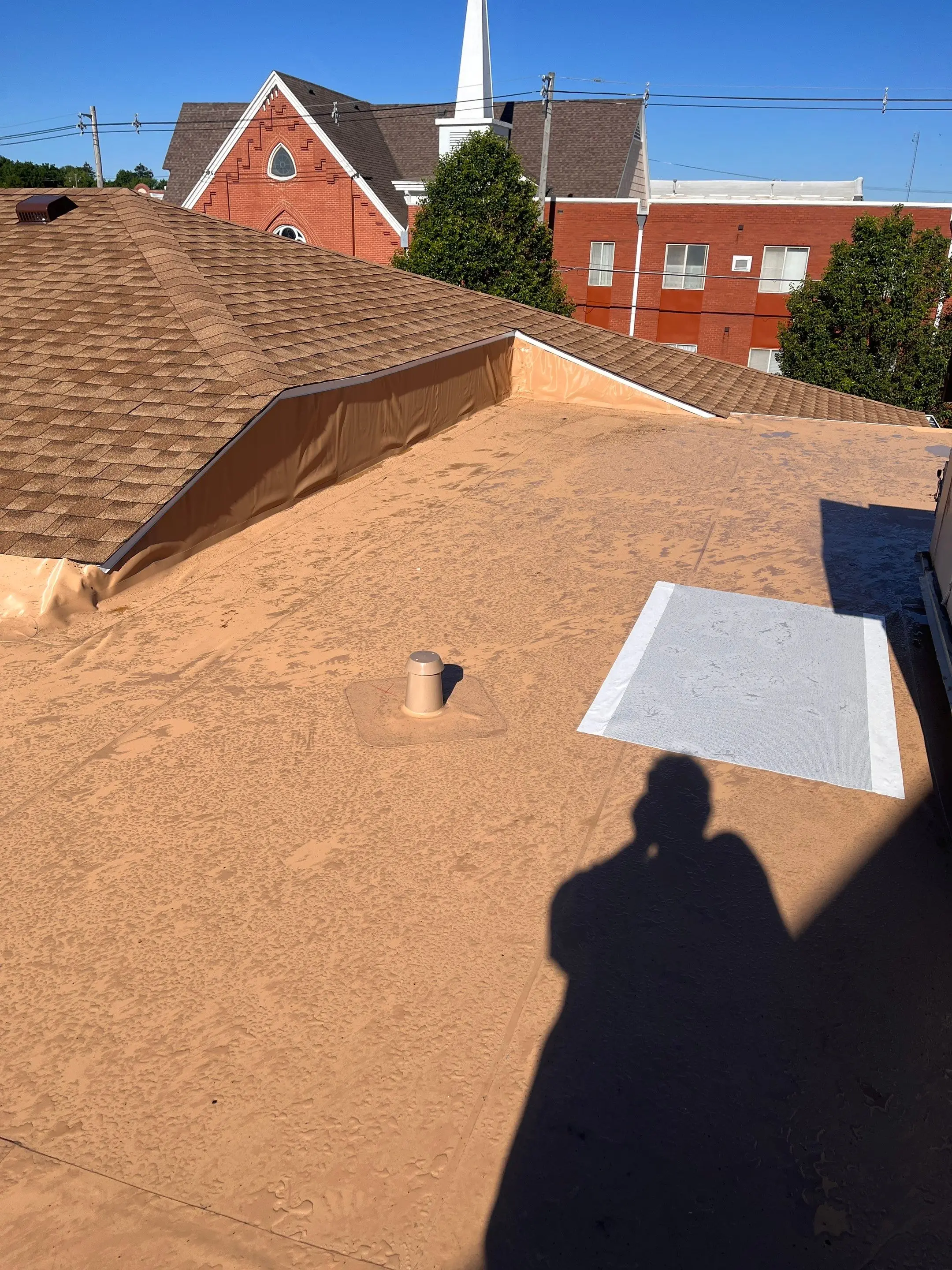 Tan Duro-Last membrane on a church flat roof in Maquoketa, Iowa, flashed into the adjoining shingle roof