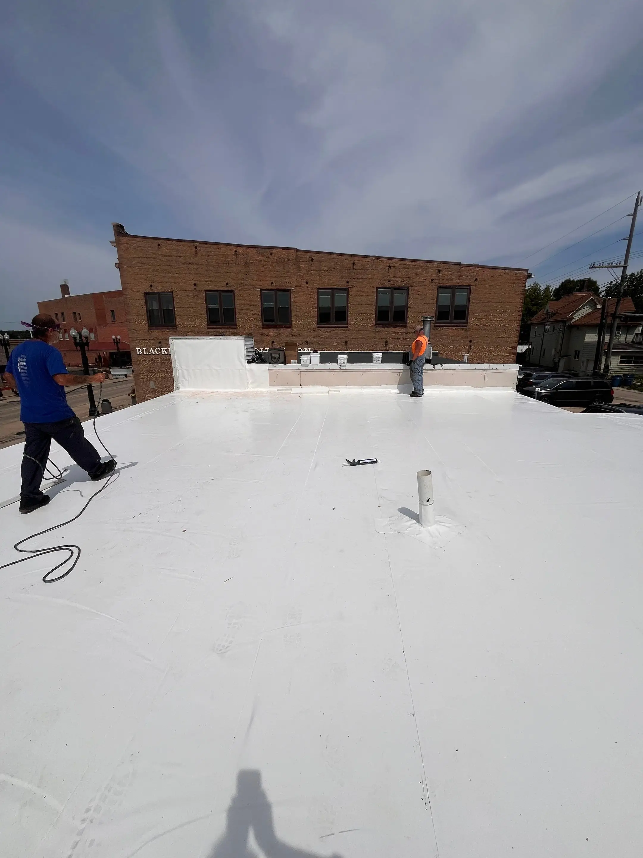 Crew member on a finished white Duro-Last roof over a commercial property in Savanna, Illinois
